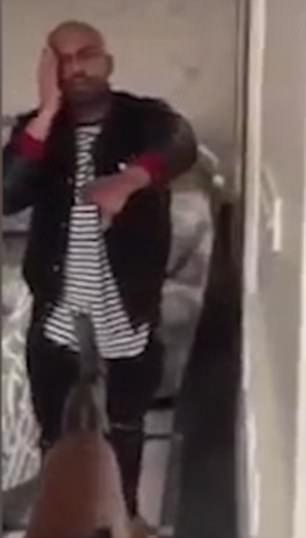 An alleged victim holds his bleeding head as a gun is pointed at him
