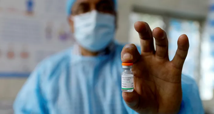 عامل صحي عراقي يعرض لقاح فيروس كورونا المستجد في بغداد، 2 مارس/ آذار 2021 عامل صحي عراقي يعرض لقاح فيروس كورونا المستجد في بغداد، 2 مارس/ آذار 2021