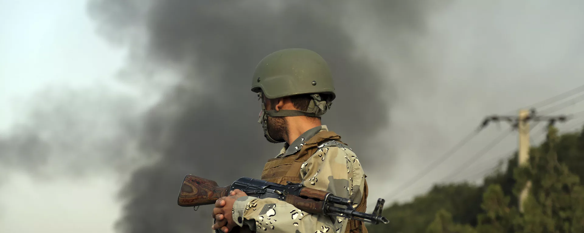 صورة أرشيفية لجندي أفغاني، ودخان متصاعد جراء حادث إرهابي. - سبوتنيك عربي, 1920, 11.07.2021