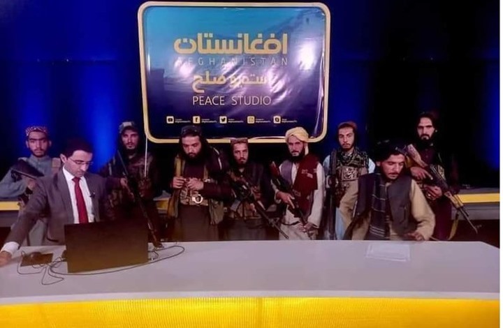 مذيع يجري حوارا مع قيادي بطالبان والسلاح فوق رأسه (شاهد)