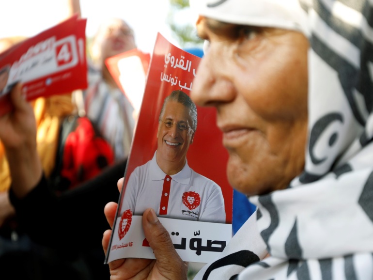 b72f6791-ec83-4190-a3a7-6c5e3f35608f A supporter of presidential candidate in detention, Tunisian media mogul Nabil Karoui, carries his picture during an election campaign rally in Tunis, Tunisia, September 13, 2019. REUTERS/Zoubeir Souissi