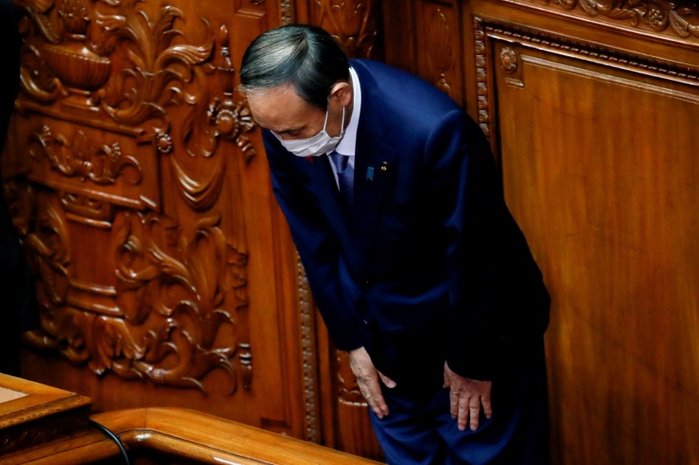 Japan's outgoing Prime Minister Yoshihide Suga bows towards lawmakers after casting his vote to elect the new prime minister at the Lower House of the Parliament in Tokyo
