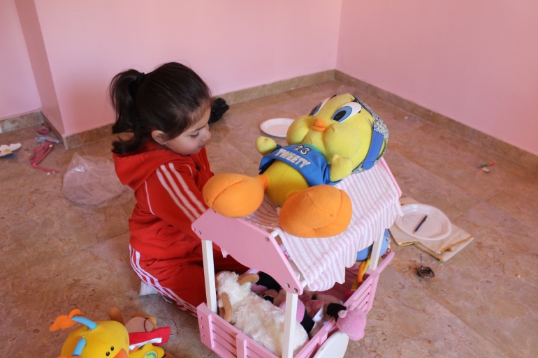 7-الطفلة إيلياء أب الحلاوة تلهو في غرفتها التي ستتحول إلى ركام في أي لحظة(الجزيرة نت)