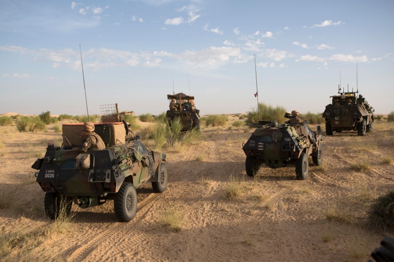 French soldiers from Operation Barkhane patrol north of Timbuktu November 6, 2014. If the French army and its allies are to keep al Qaeda at bay in the desert of northern Mali they must stop them seizing the biggest prizes in the sea of white sand - the wells. So this month a column of soldiers from France, Burkina Faso and Mali, in armoured vehicles and pick-up trucks, churned toward a village north of Timbuktu where herders water camels and goats. They were looking for signs of infiltration by militants who need water as much as the locals do and aim to convert villages to their ideology. Picture taken November 5, 2014. REUTERS/Joe Penney (MALI - Tags: MILITARY POLITICS CIVIL UNREST)
