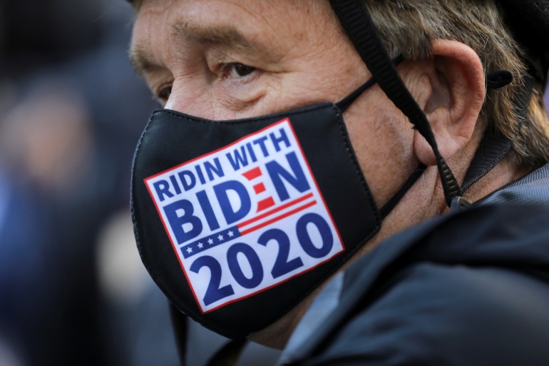 A man wearing a "Biden 2020" face mask attends a rally at the New York Public Library, the day after Election day, in Manhattan