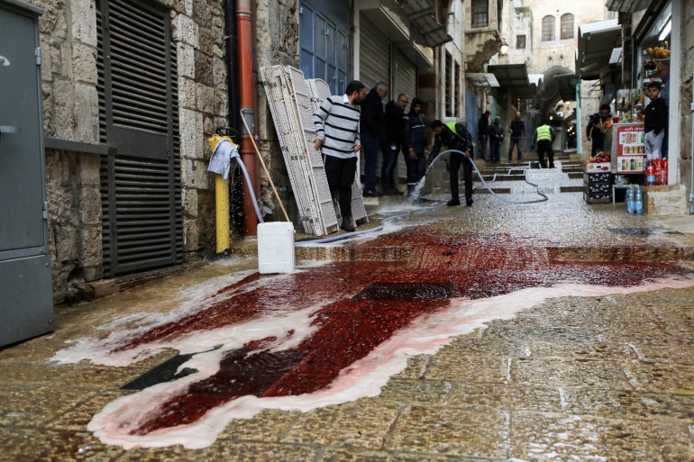 2021-11-21t093910z مقتل مستوطن وجرح 4 أشخاص بالقدس.. من قام بالعملية؟ Workers clean the pavement of blood following a shooting incident in Jerusalem's Old City November 21, 2021. REUTERS/Ammar Awad TPX IMAGES OF THE DAY