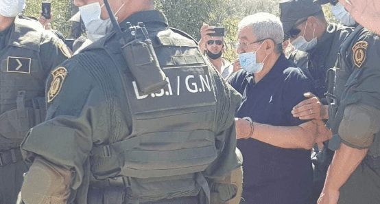 وزير عربي سابق يحضر جنازة أخيه مكبلا بالأصفاد