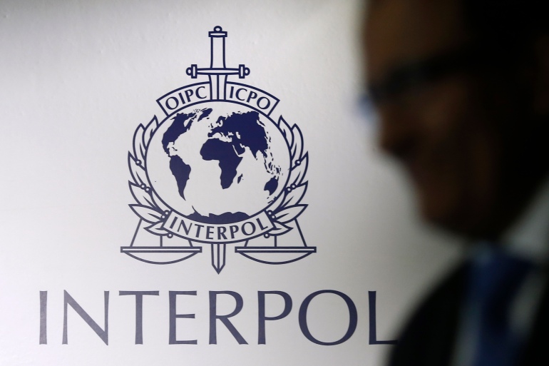 rtr48mgw-1 A man passes an Interpol logo during the handing over ceremony of the new premises for Interpol's Global Complex for Innovation in Singapore