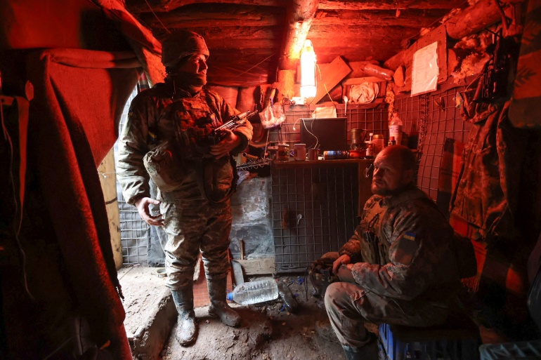 Service members of the Ukrainian armed forces stand guard at combat positions near Zolote
