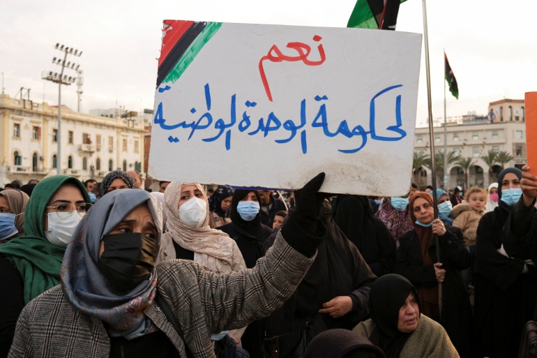 rts5dvsa-1 Protest against the parliament's latest decision to name a new interim prime minister, at Martyr's square in Tripoli A woman holds a placard that reads "Yes to the Government of National Unity" as she participates in a protest against the parliament?s latest decision to name a new interim prime minister, at Martyr's square in Tripoli, Libya February 11, 2022. REUTERS/Nada Harib DATE 11/02/2022 SIZE 4416 x 2902 SOURCE REUTERS/Nada Harib
