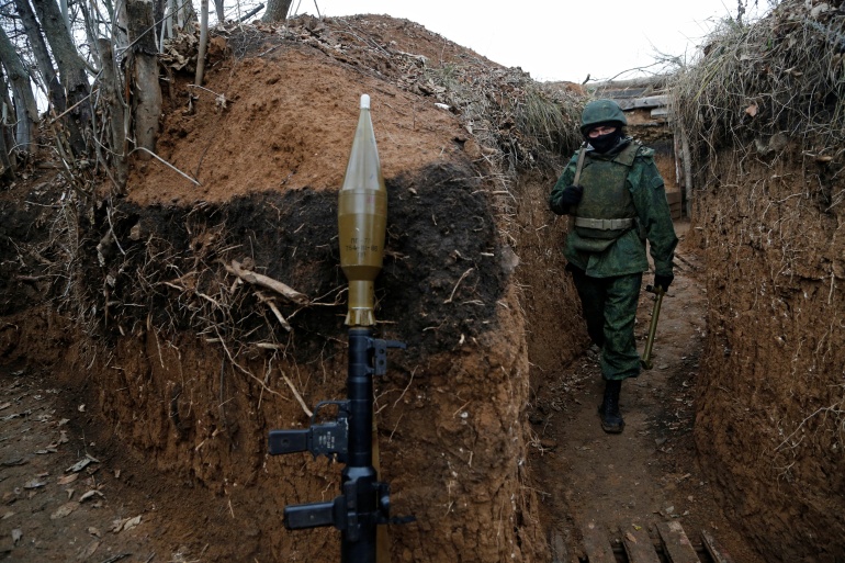 A militant of the self-proclaimed Luhansk People's Republic walks at fighting positions in Luhansk Region