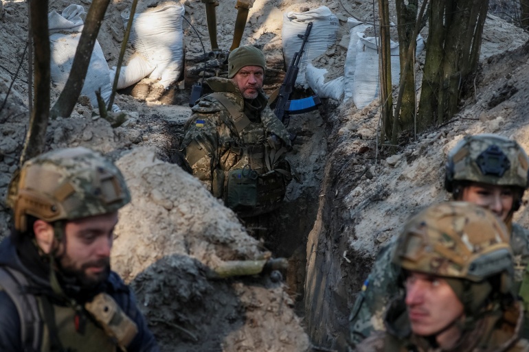 Ukrainian service members stand at a position on the front line in the north Kyiv region