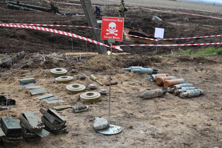 This picture shows unexploded munitions and other explosive devices as members of a demining team of the State Emergency Service of Ukraine clear mines off a field not far from the town of Brovary, northeast of Kyiv, on April 21, 2022, amid Russian invasion of Ukraine. (Photo by Aleksey Filippov / AFP)