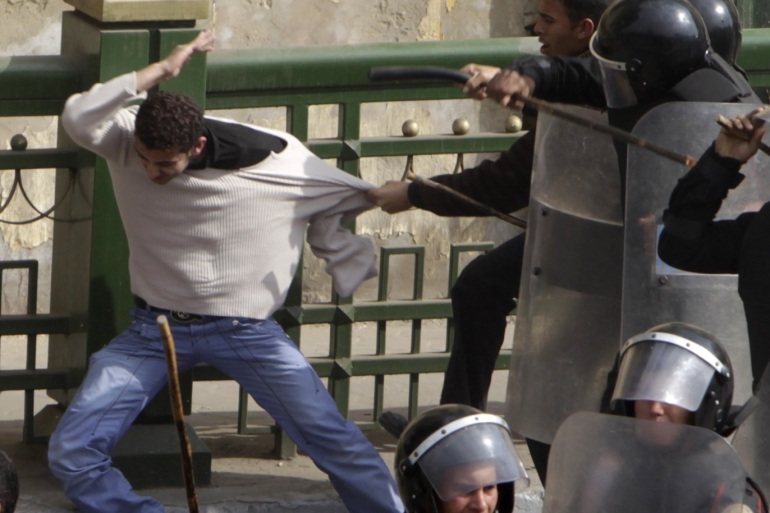 Police beat a protester during clashes in Cairo January 28, 2011. Police and demonstrators fought running battles on the streets of Cairo on Friday in a fourth day of unprecedented protests by tens of thousands of Egyptians demanding an end to President Hosni Mubarak's three-decade rule. REUTERS/Amr Abdallah Dalsh (EGYPT - Tags: POLITICS CIVIL UNREST IMAGES OF THE DAY)