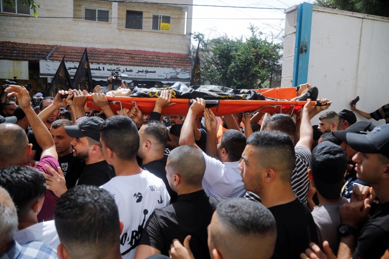 dasd-1 SENSITIVE MATERIAL. THIS IMAGE MAY OFFEND OR DISTURB Mourners carry the body of Palestinian militant Amjad Al Fayed, who was killed in clashes during an Israeli raid, during his funeral in Jenin in the Israeli-occupied West Bank May 21, 2022. REUTERS/Raneen Sawafta