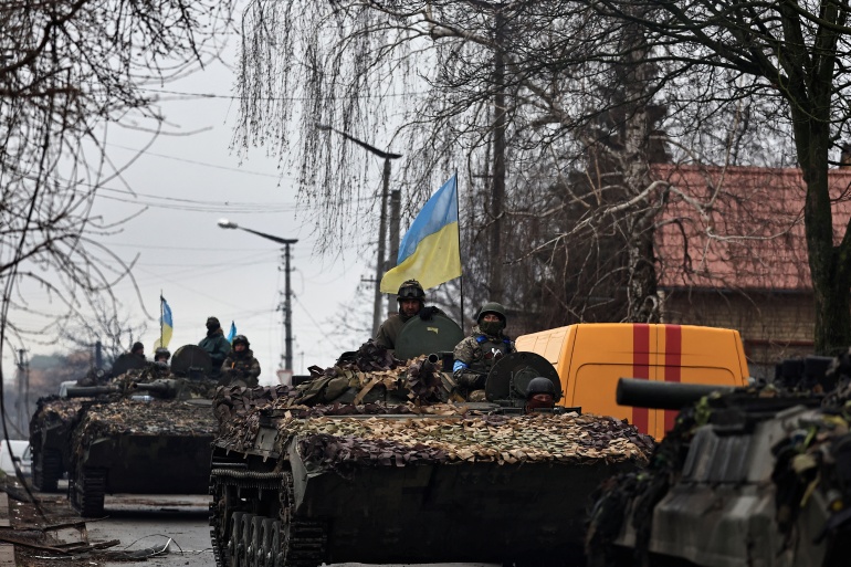 rts6qw9f-1 Ukrainian soldiers are pictured on their tanks as they drive along the street, amid Russia's invasion on Ukraine, in Bucha, in Kyiv region