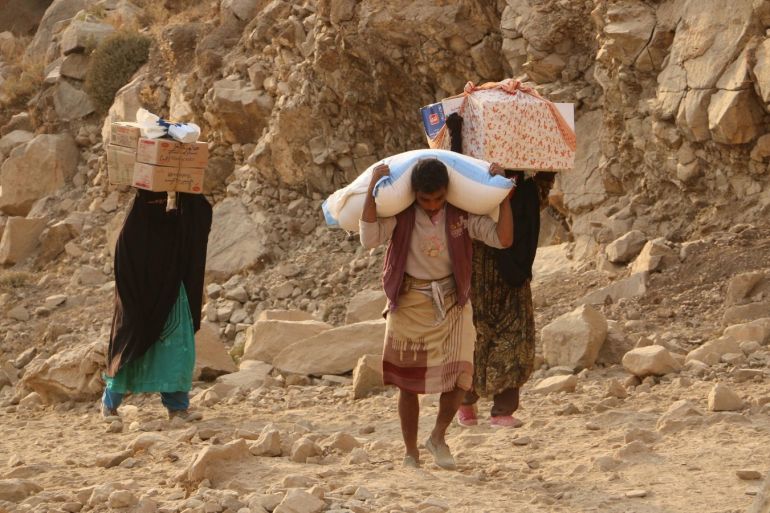 af5baa30-38ee-4a88-83ae-d4d5a7ba1b78-1 In this photo taken on Sunday, Jan. 17, 2016, Yemenis carry relief supplies as they walk along a path after Shiite rebels, known as Houthis besieging the city of Taiz, Yemen. Residents have been going hungry for weeks, the WFP said. (AP Photo/Abdulnasser Alseddik)