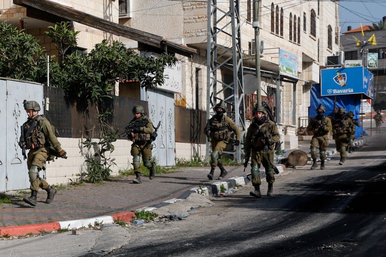 2022-03-palestinians-violence-2-1 Israeli soldiers run during a raid in Jenin in the Israeli-occupied West Bank March 30, 2022. REUTERS/Mohamad Torokman
TPX IMAGES OF THE DAY