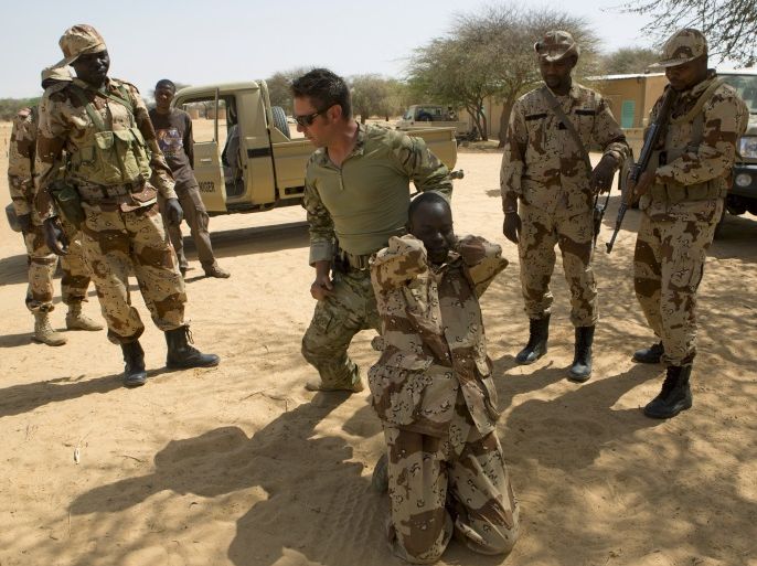 c57e7a37-5cbc-4eb7-b9c3-0a0abff7a21e-1 A U.S. special forces soldier demonstrates how to detain a suspect during Flintlock 2014, a U.S.-led international training mission for African militaries, in Diffa, March 4, 2014. On a dusty training ground in Niger, U.S. Special Forces teach local troops to deal with suspects who resist arrest. The drill in the border town of Diffa is part of Operation Flintlock, a counter-terrorism exercise for nations on the Sahara's southern flanks that the United States organises